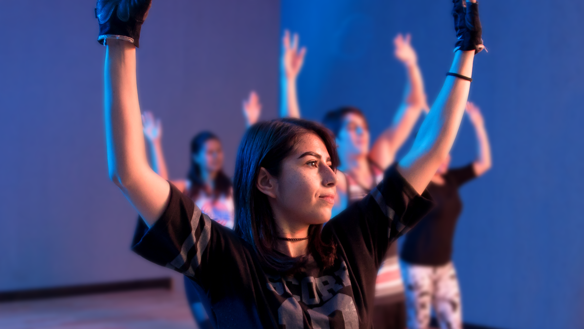torso de mujer ligeramente de lado, con los brazos esitirados hacia arriba y la