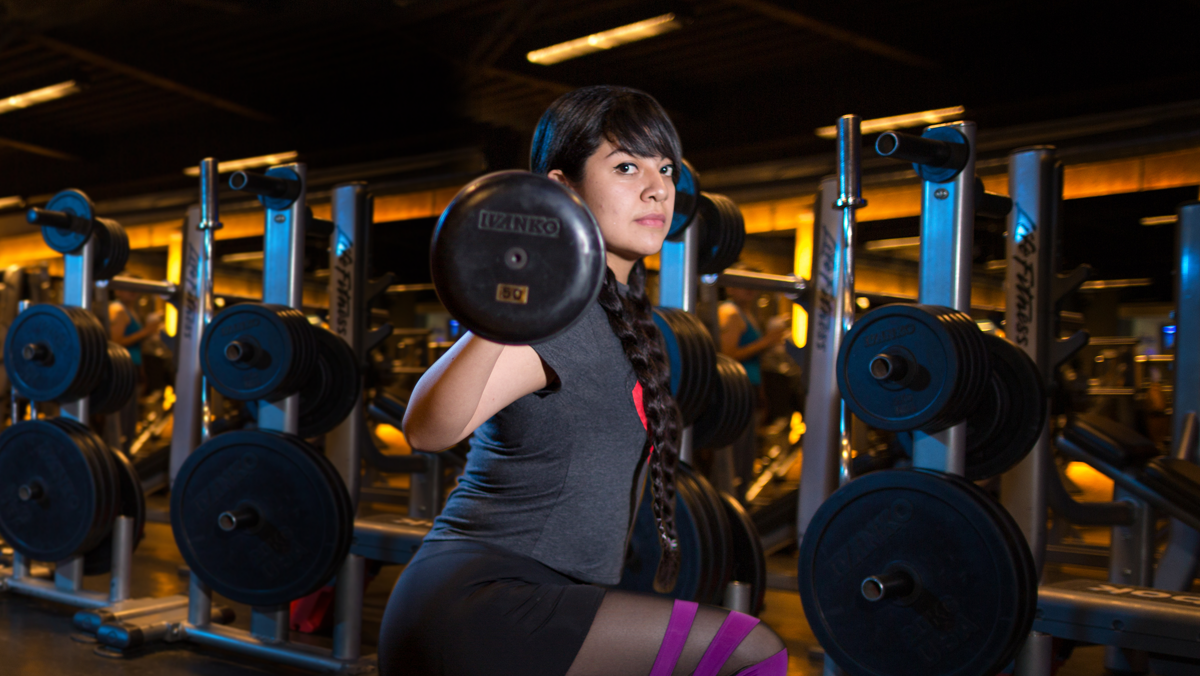 mujer con una barra en la espalda realizando un desplante