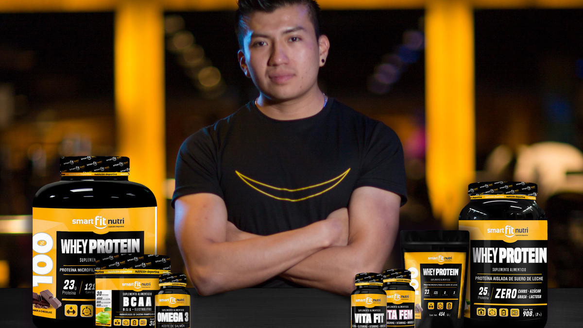 hombre con los brazos cruzados, rodeado de algunos botes de distintos suplementos alimenticios de Smart Fit Nutri