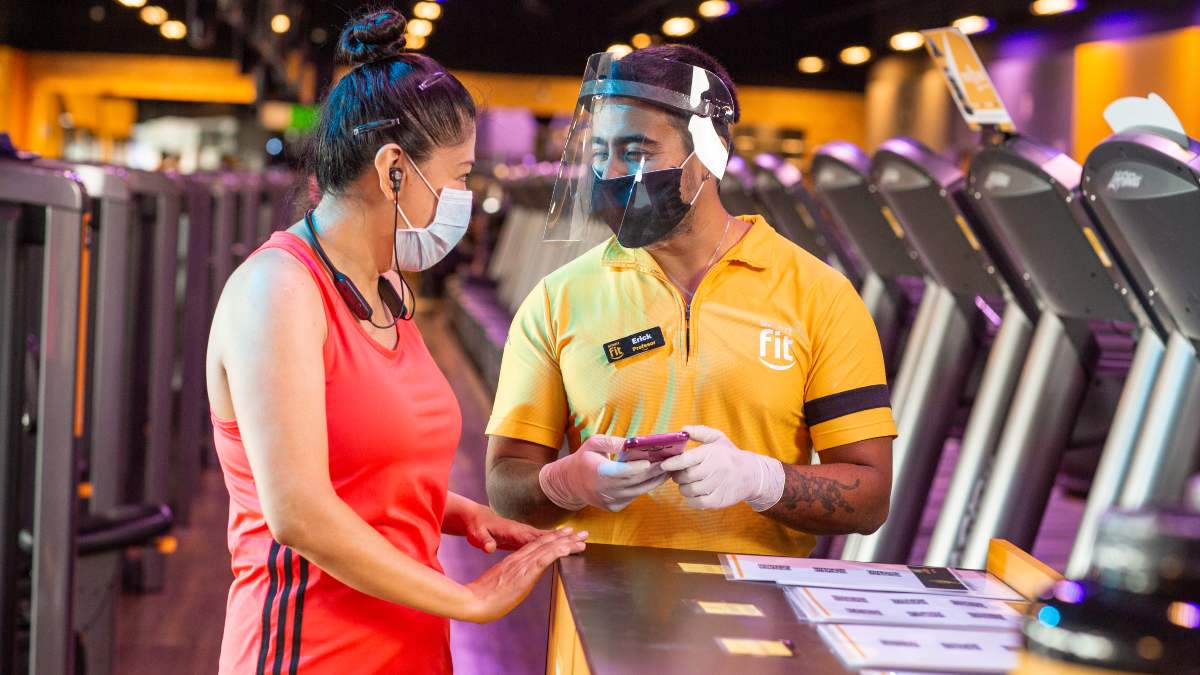 mujer en el gimnasio smart fit recibiendo su rutina fitness