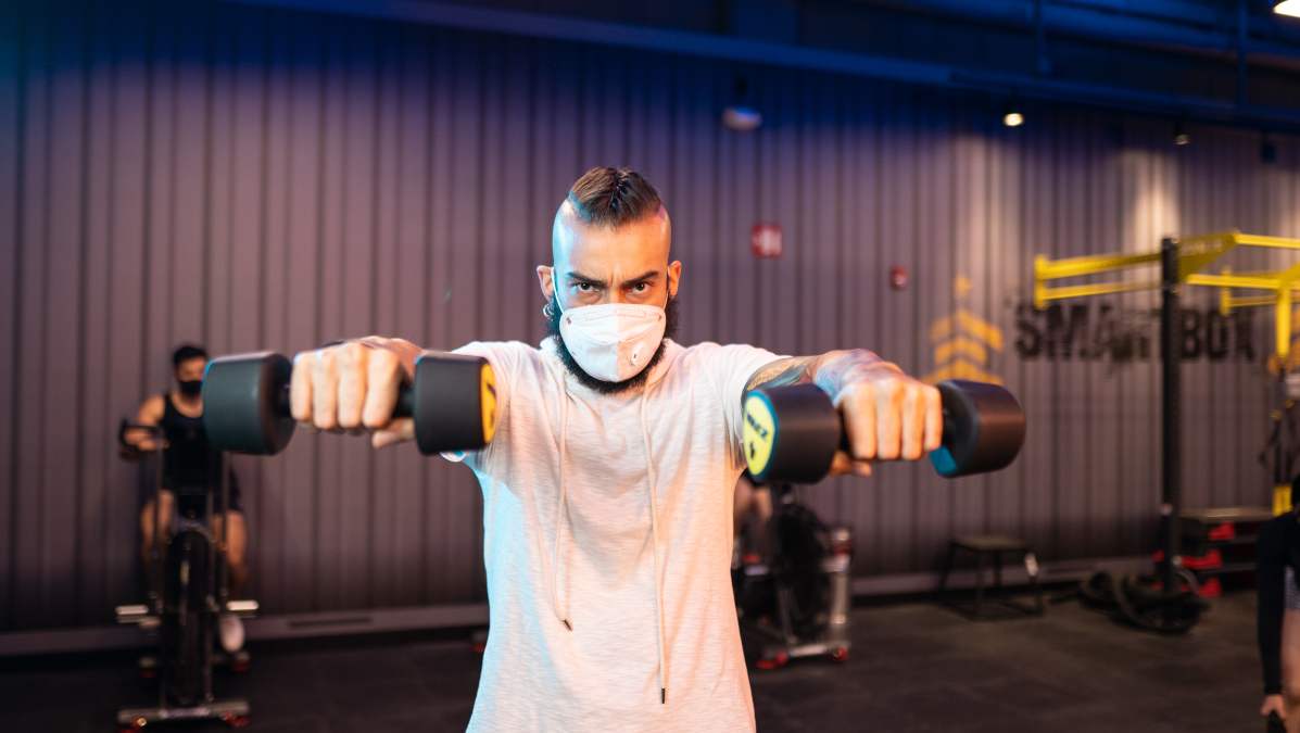 hombre realizando un ejercicio con pesas con un tipo de agarre del gym