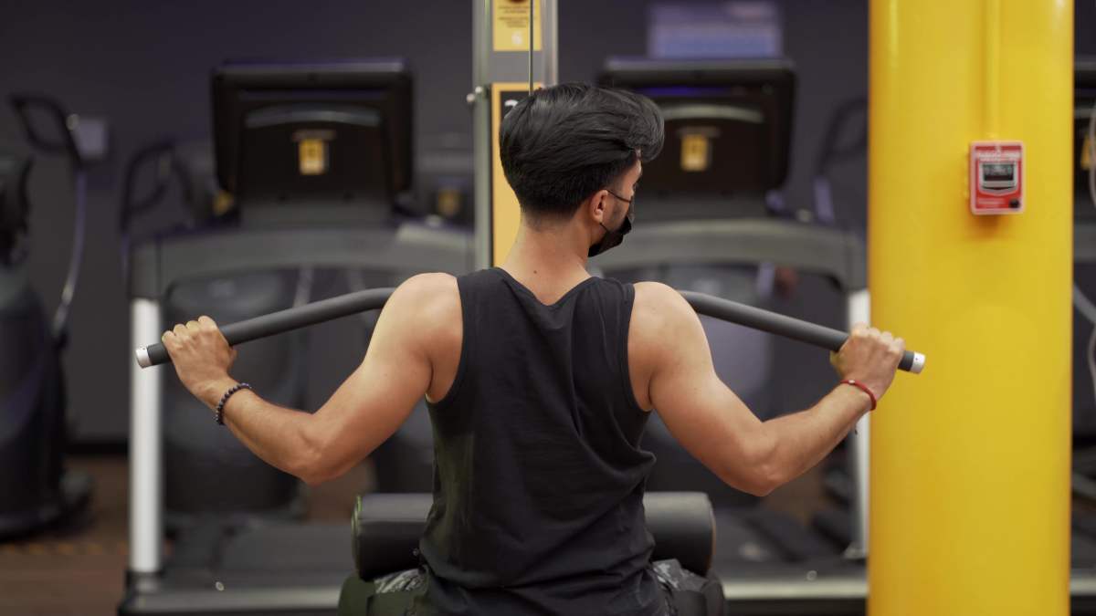hombre realizando ejercicios para espalda en el gimnasio, se trata de jalones al pecho