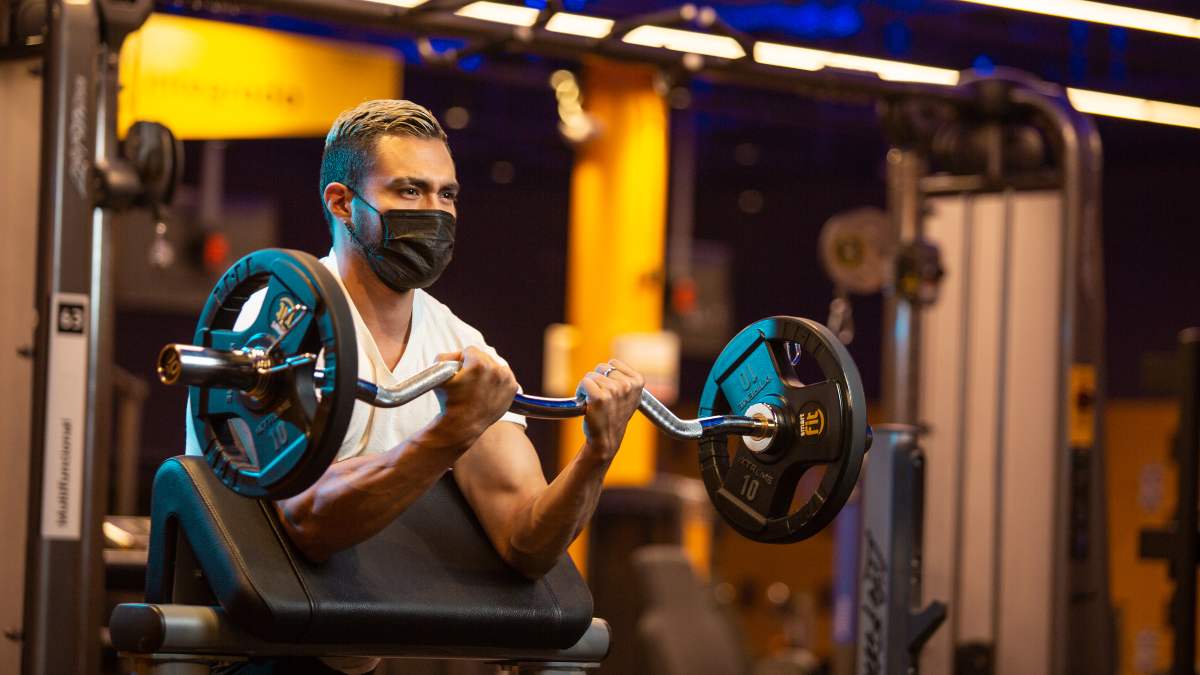 hombre realizando curl predicador hasta llegar al fallo muscular