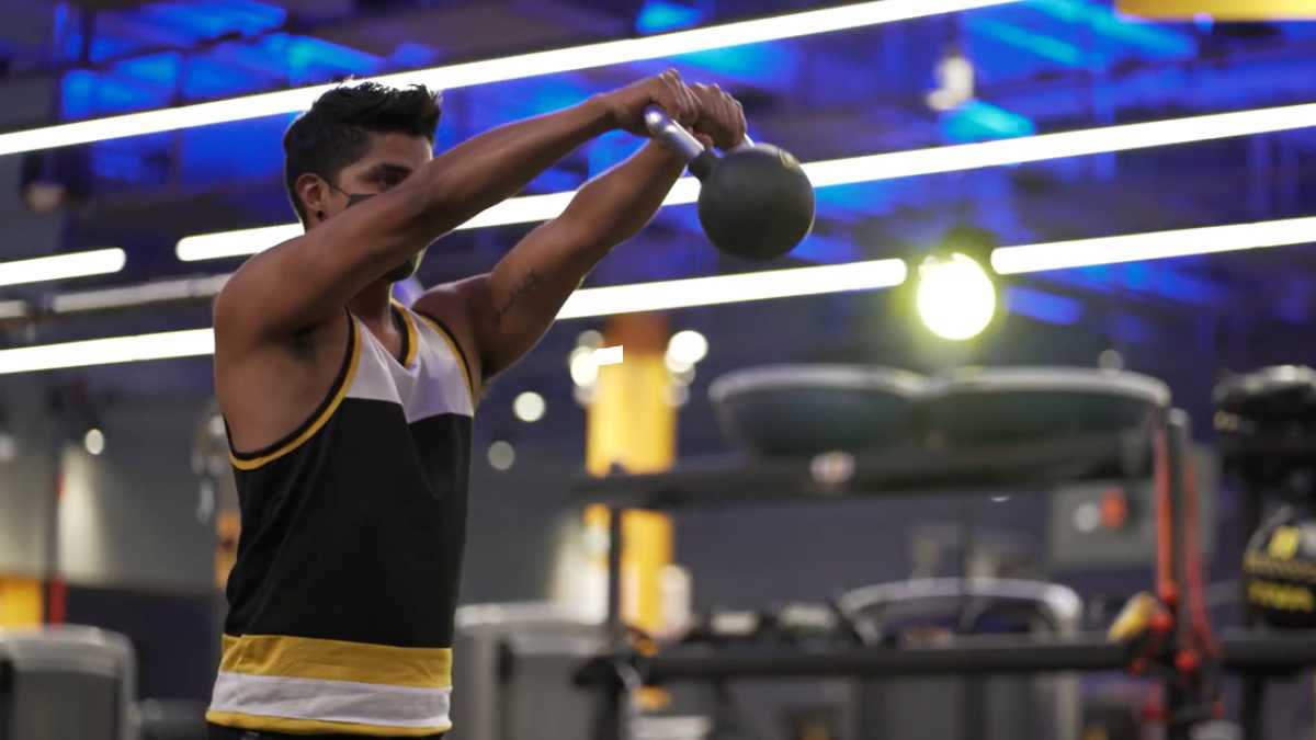 hombre realizando un kettlebell swing en el gimnasio