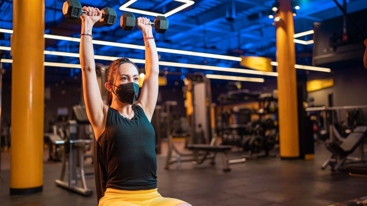 mujer realizando un press tipo arnold