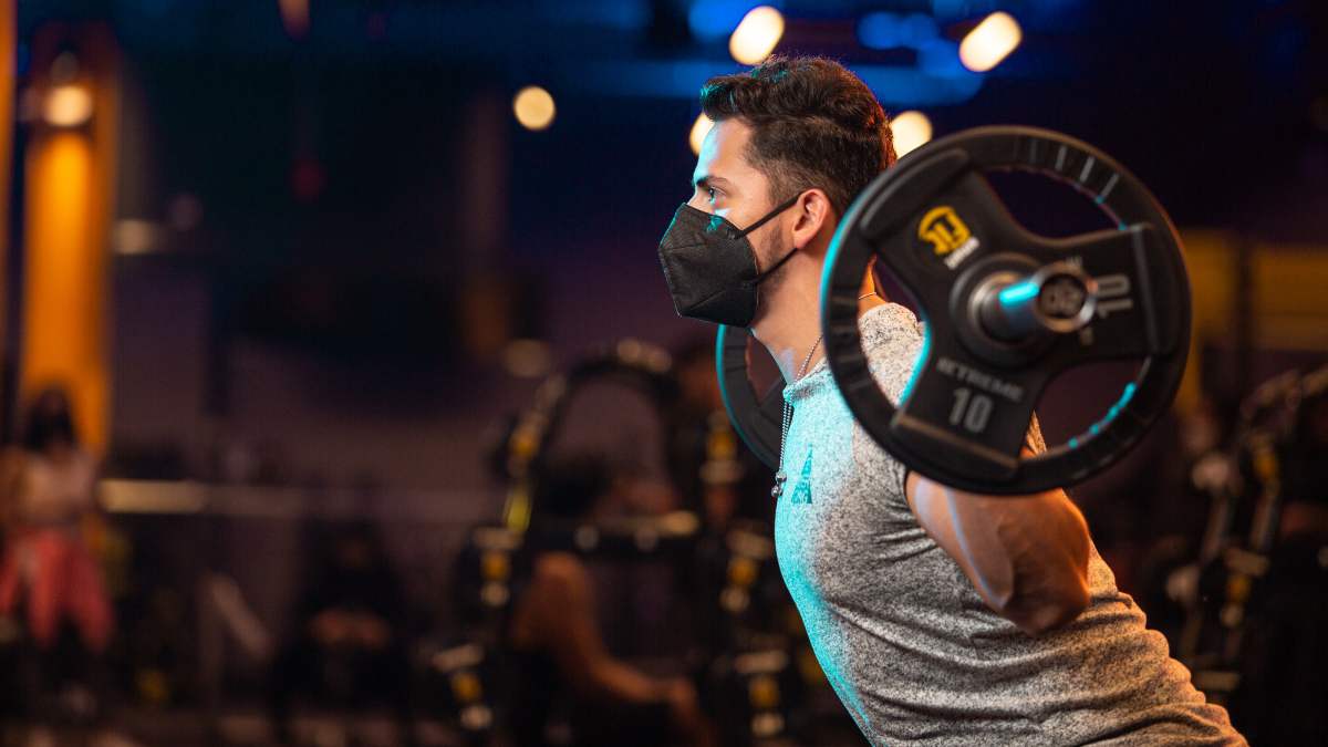 hombre realizando una sentadilla bulgara con barra en el gimnasio