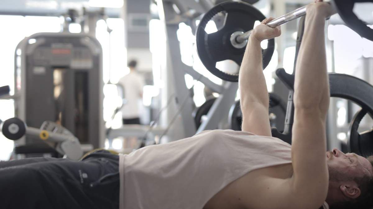 hombre realizando un ejercicio de tríceps con barra