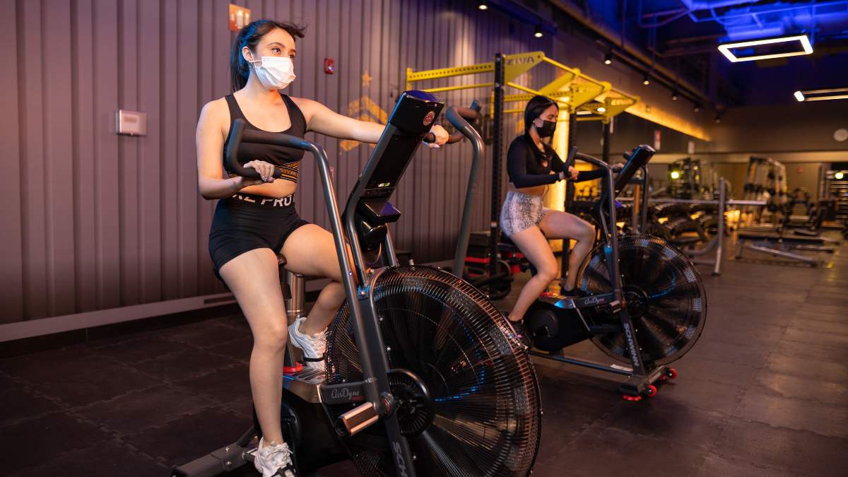 mujer realizando ejercicio en una bicicleta fija en el gimnasio