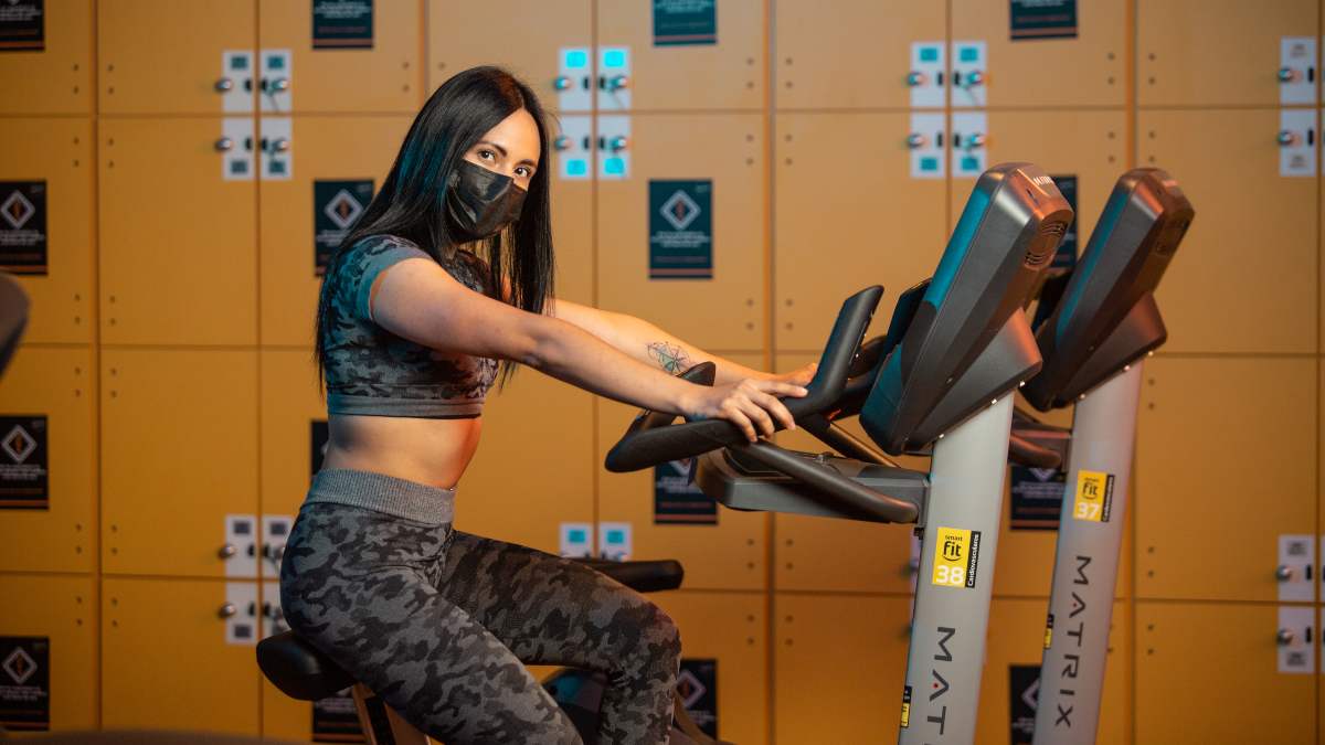 mujer haciendo ejercicio en una bicicleta en el gimnasio que forma parte de los ejercicios de bajo impacto