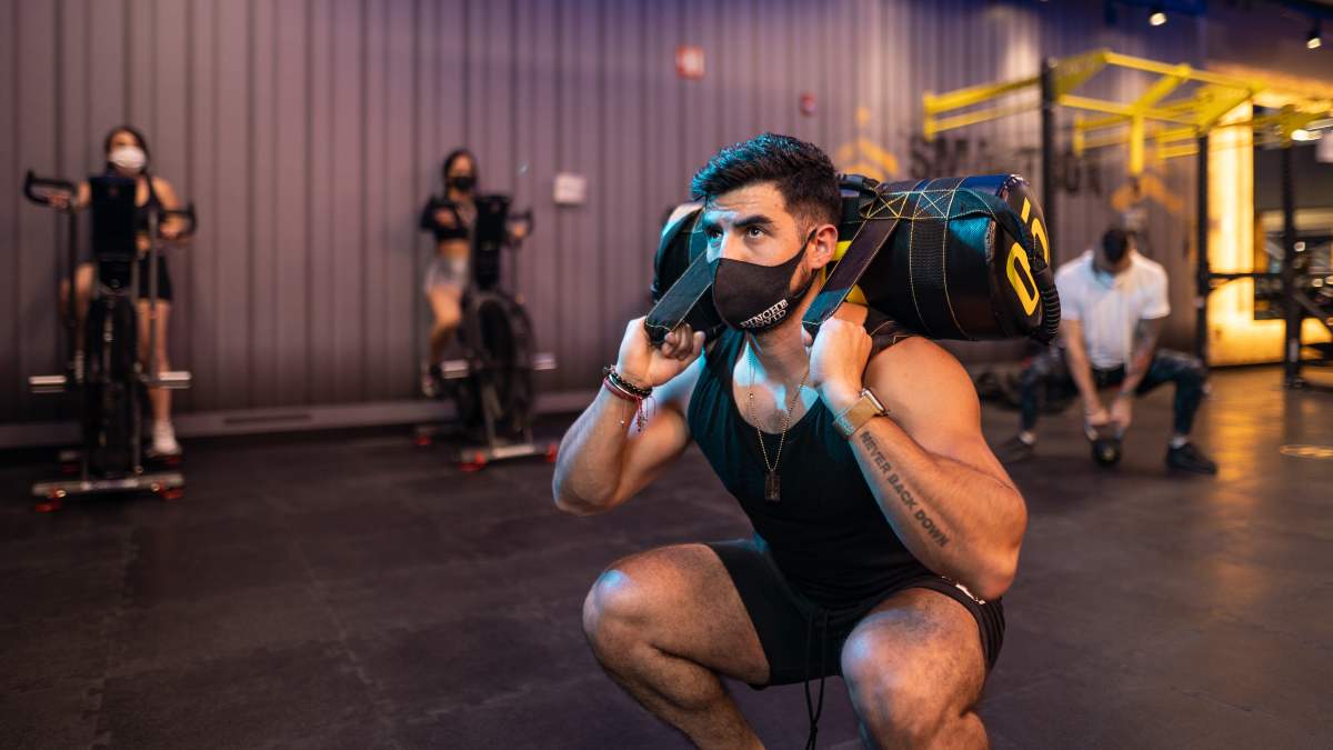 hombre realizando una sentadilla con un costal como parte de una entrenamiento tabata