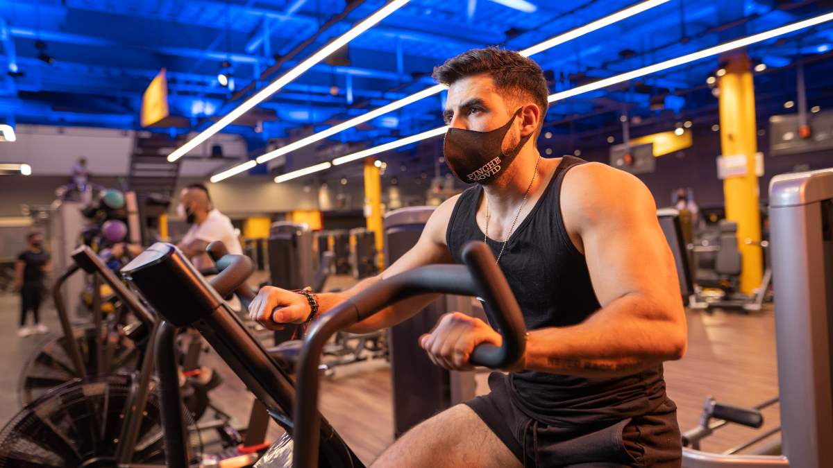 hombre sobre una bicicleta fija en un gimnasio de smart fit