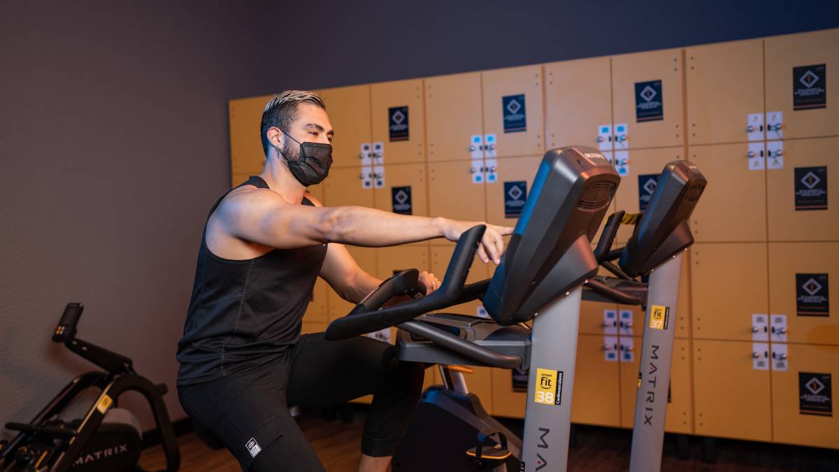hombre sentado en una bicicleta eliptica haciendo preparandose para iniciar su rutina