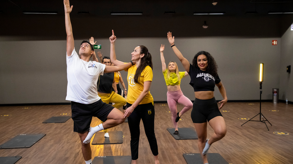 Usuarios de un gimnasio Smart Fit en una clase grupal con la guía de un profesor