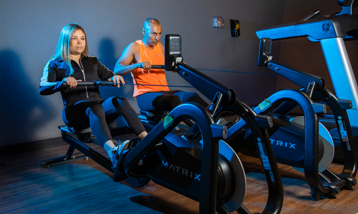 hombre y mujer realizando ejercicio en las máquinas de remo en un gimnasio Smart Fit