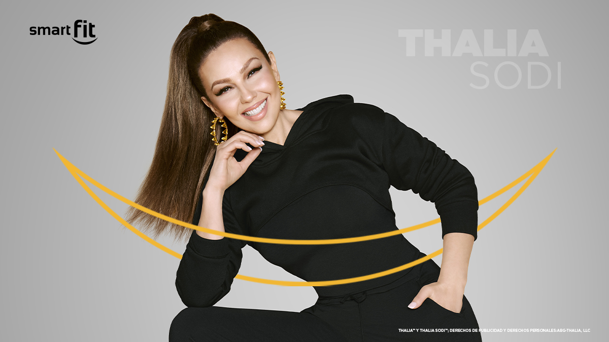 Thalia Sodi vestida con un outfit fitness de color negro con cara sonriente