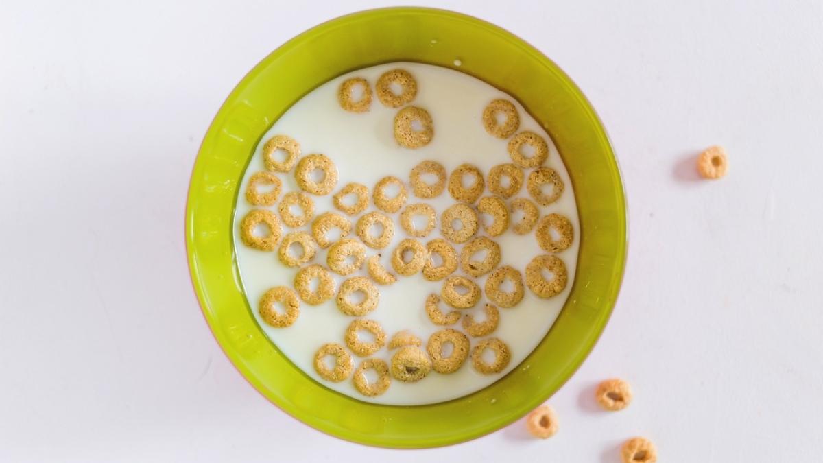 vista aerea de un plato de cereal con leche, con piezas de cereal a un costado