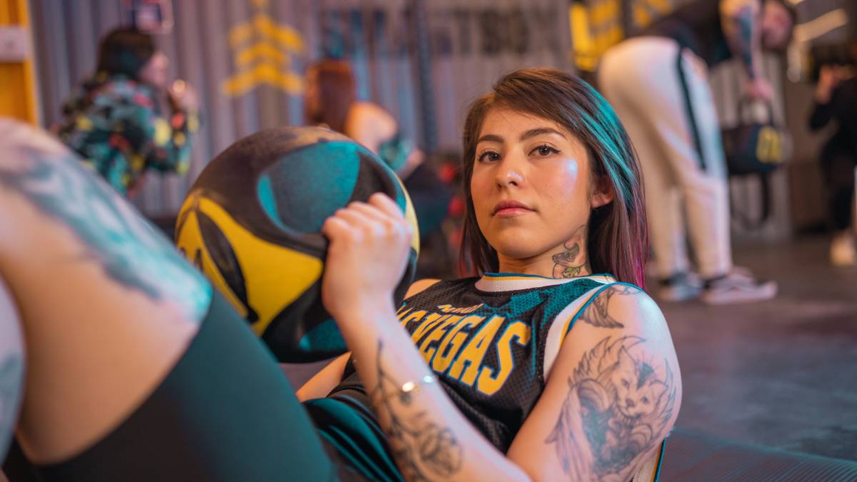 mujer recostada en el suelo sosteniendo un balón medicical con las dos manos