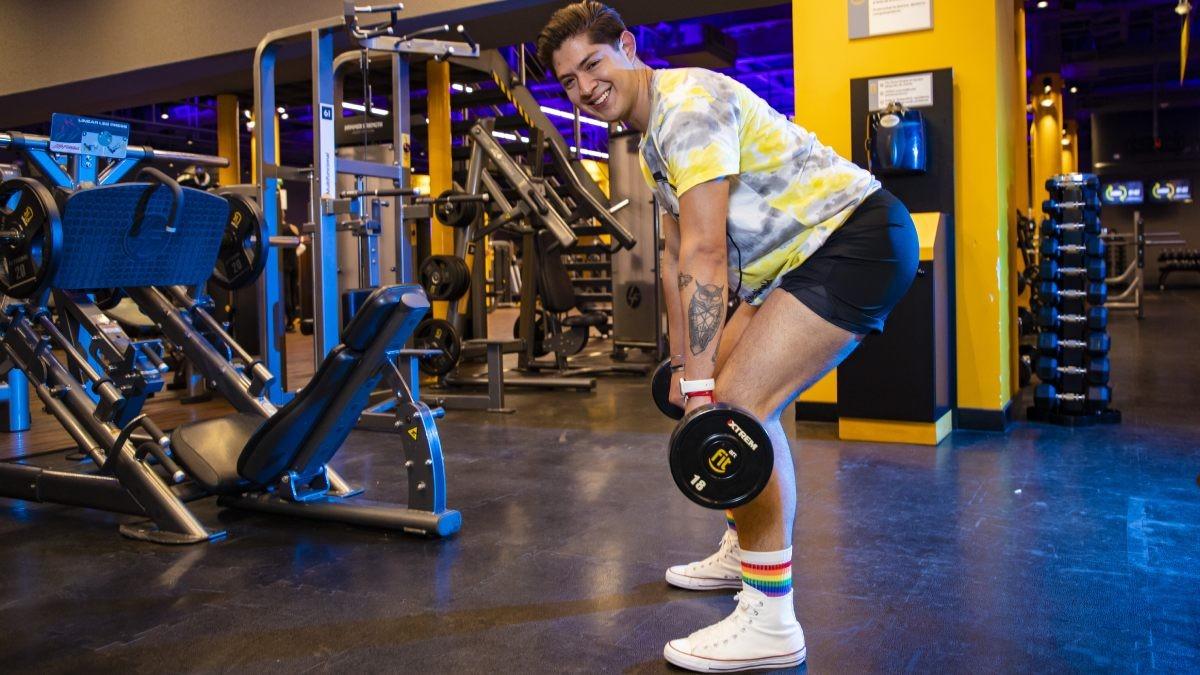 hombre de perfil con las piernas semiflexionadas, el tronco inclinado hacia adelante y con las dos manos sosteniendo una barra