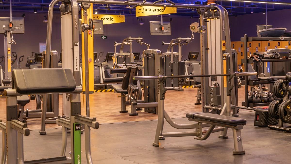 interior de un gimnasio smart fit. con banco plano, banco scott. una polea multifunción en primer plano