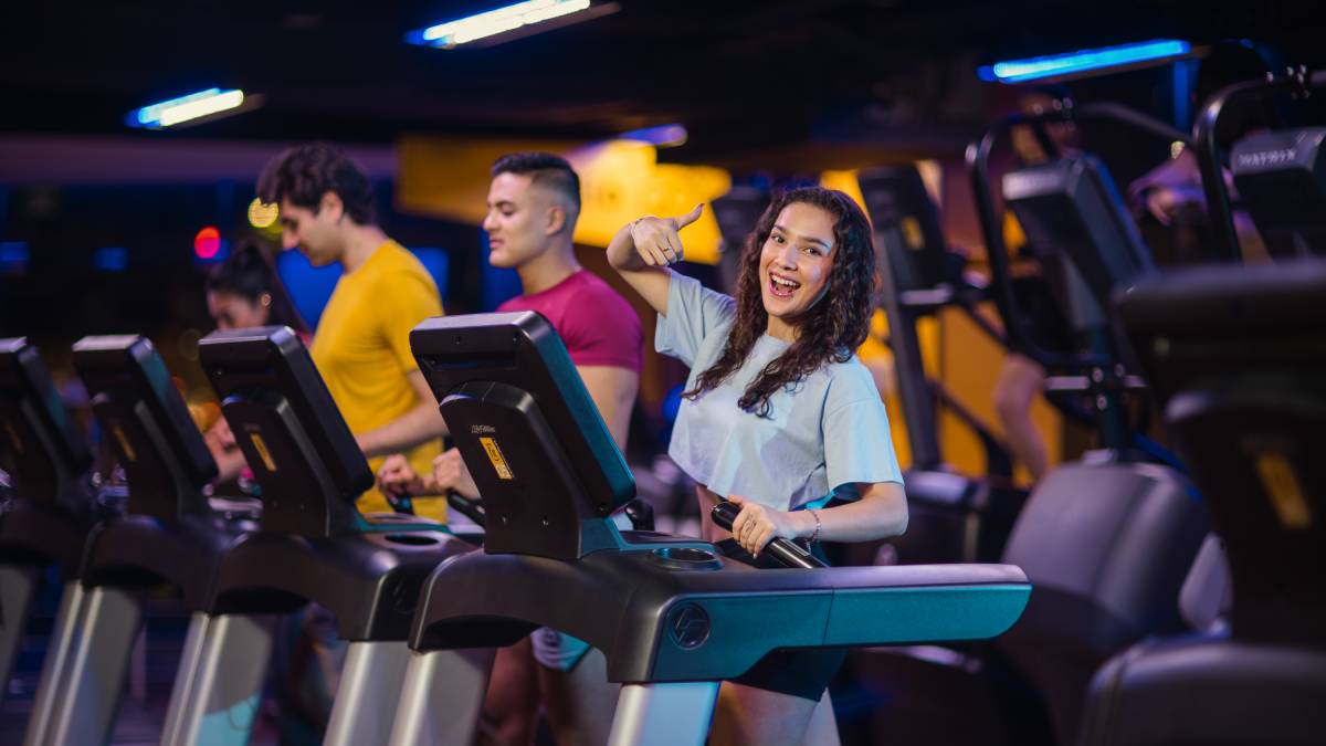 tres usuarios, una mujer dos hombres haciendo ejercicio en las caminadoras de un gimnasio de smart fit