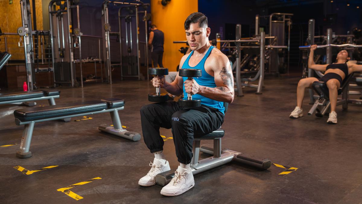 Hombre entrenando con mancuernas en gimnasios Smart Fit, demostrando como mantenerse activo en invierno es clave para aprovechar que se queman mas calorias cuando hace frio